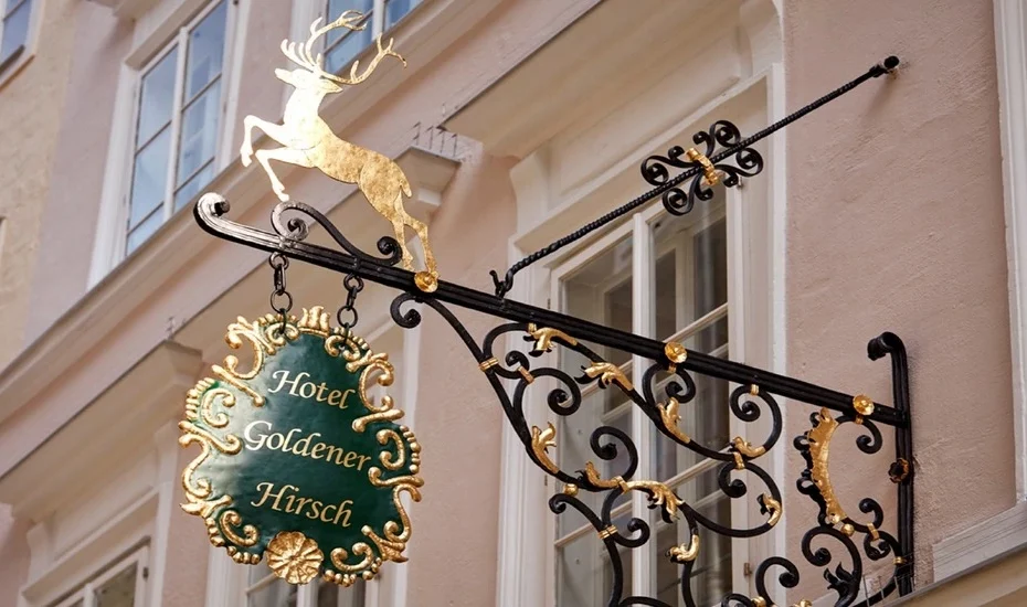 Werbeschild an der historischen Fassade Hotel Goldener Hisch Salzburg