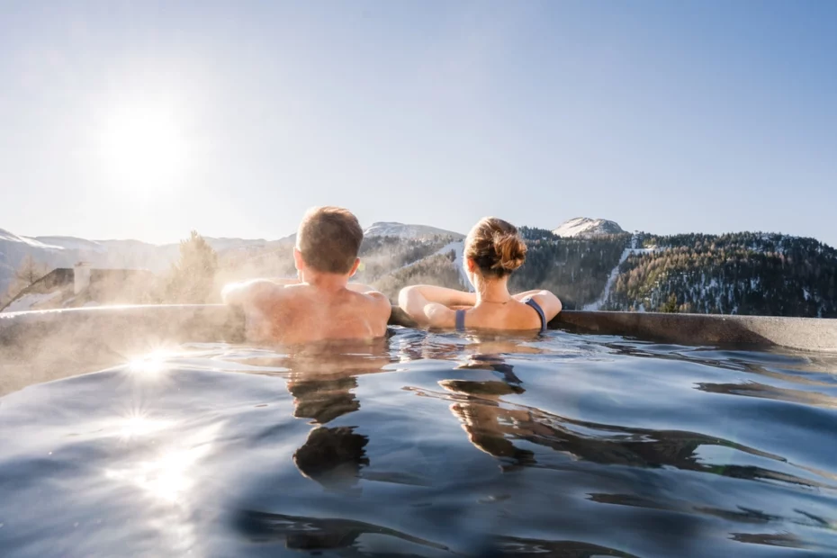 Paar im Pool eines Wellnesshotels in Österreich von hinten