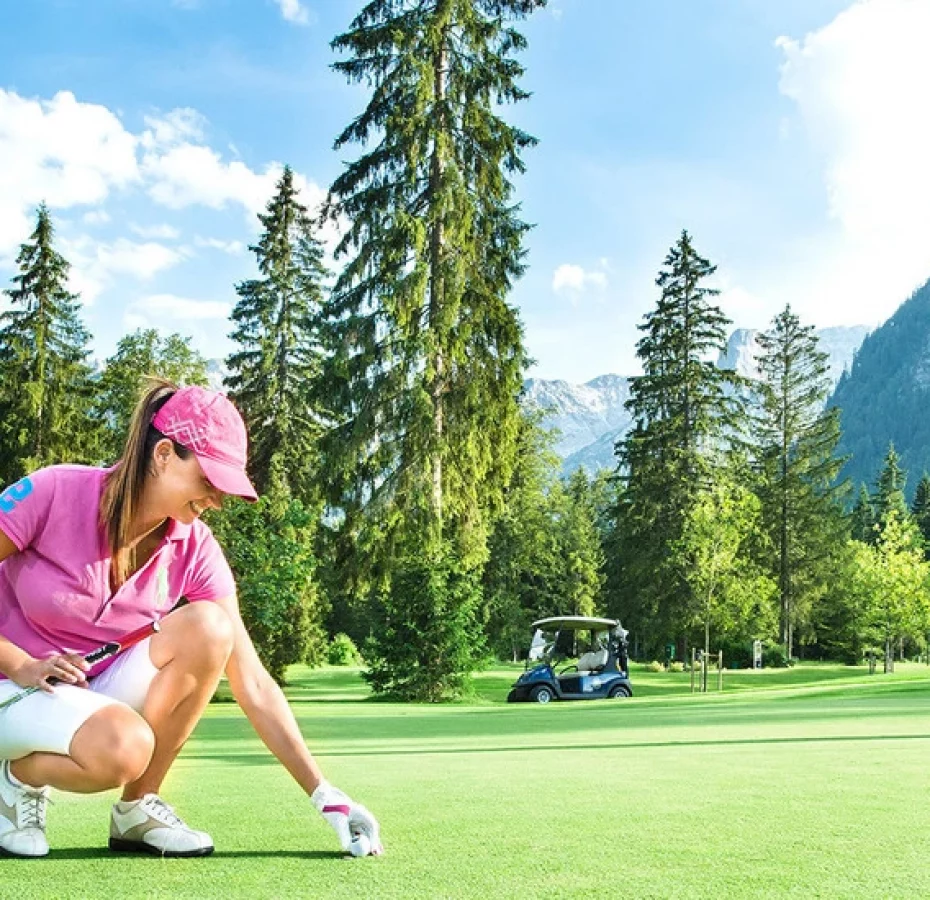 Ein Paar spielt Golf auf dem Golfplatz ihres Golfhotels in Österreich